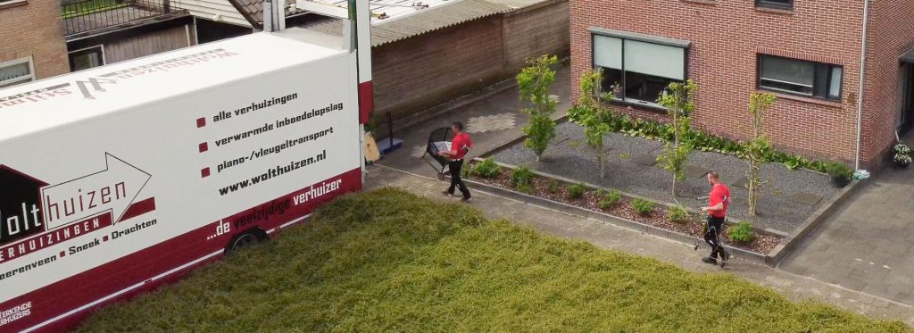 Twee personen laden spullen in, in de vrachtwagen van Wolthuizen